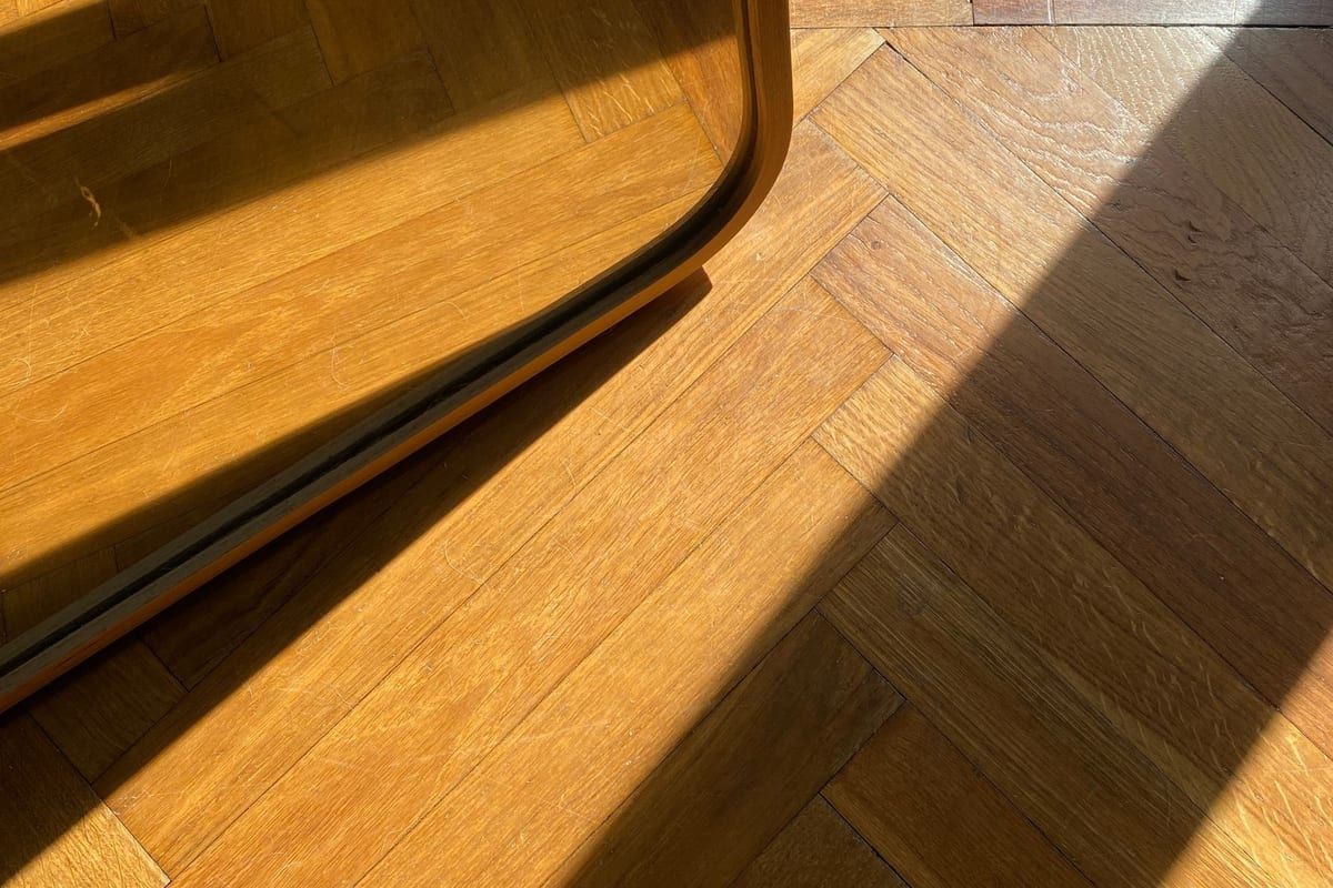 The same room re-laid in warm oak herringbone
