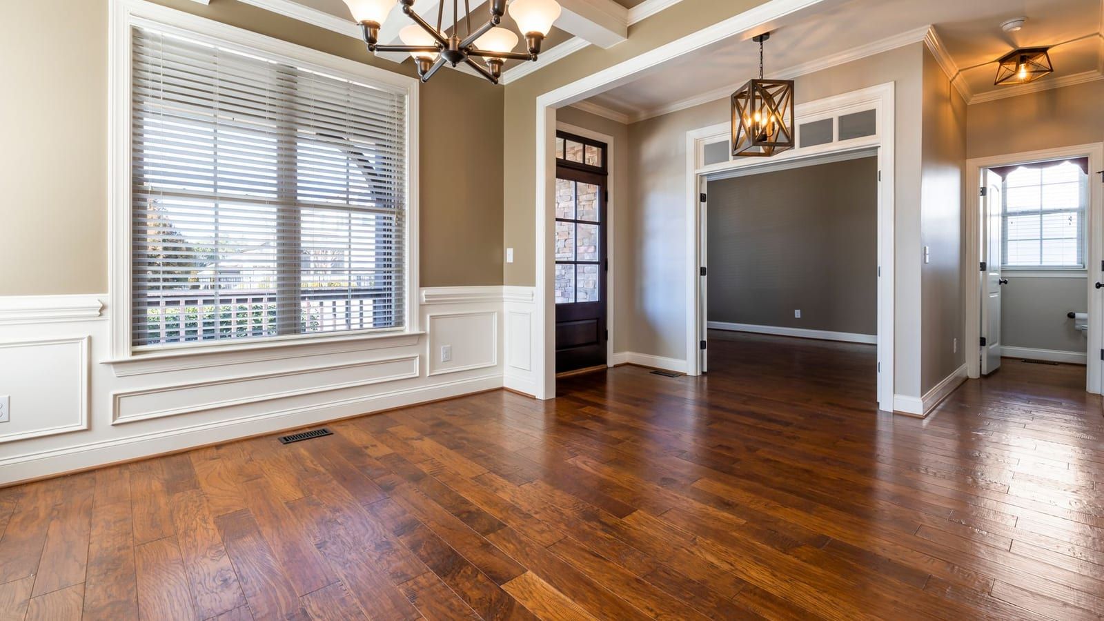 Freshly laid solid oak floor running through a bright, bay-windowed room